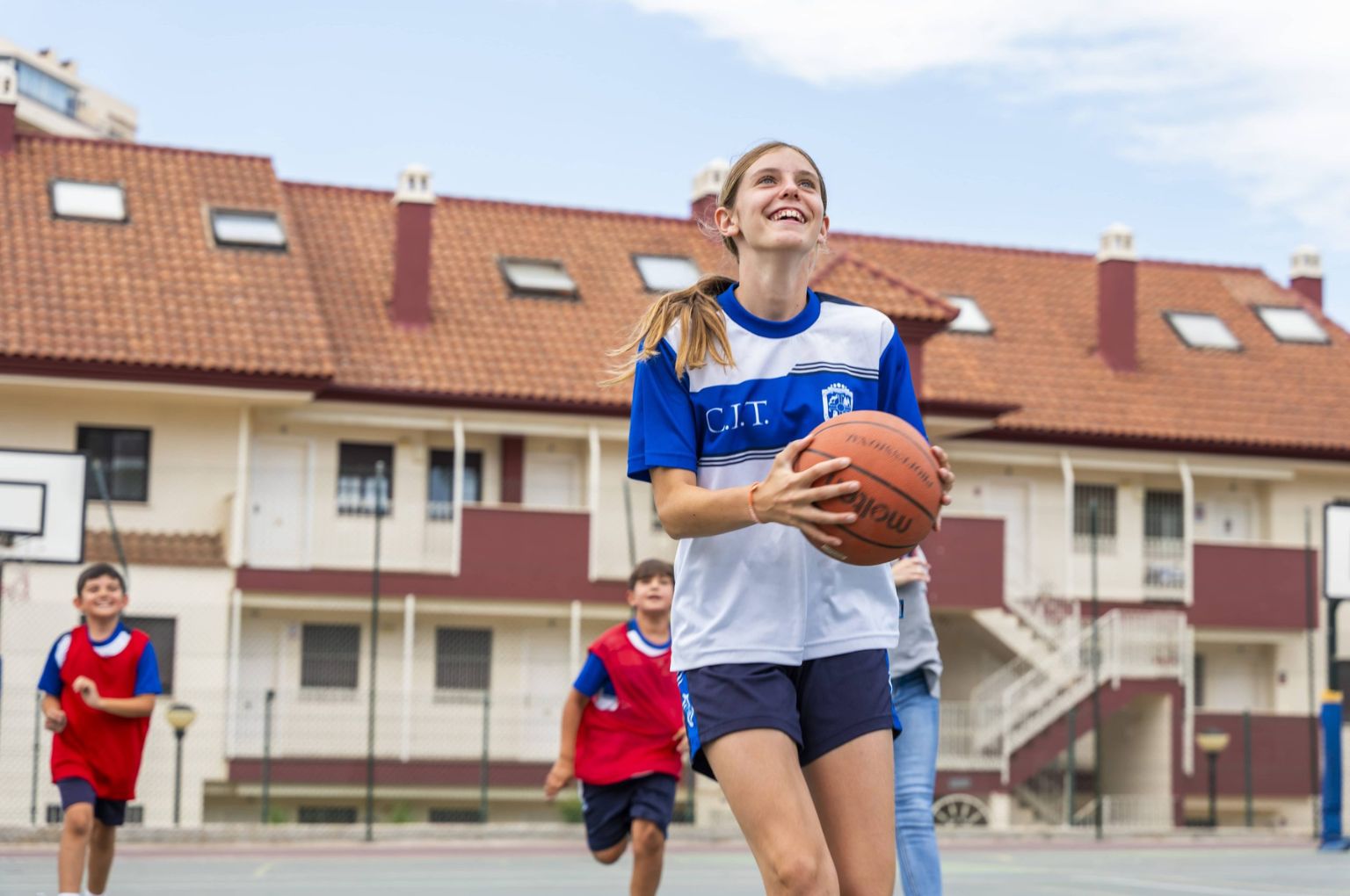 A student running with a basketball at Colegio Internacional Torrequebrada