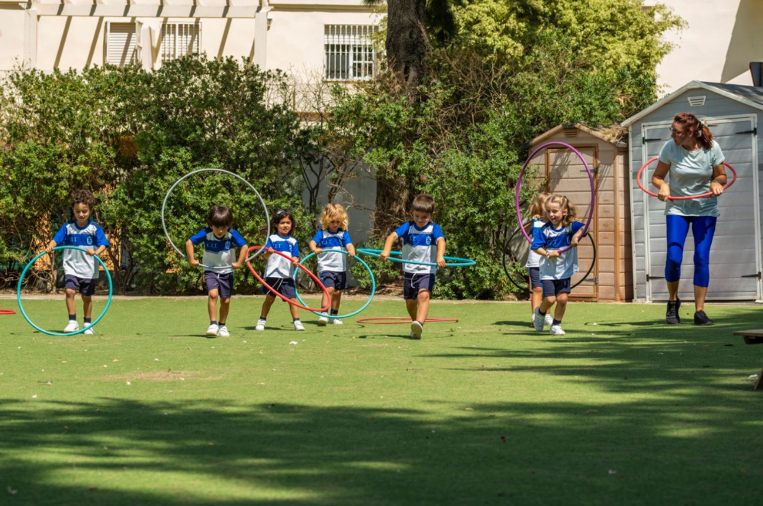 Children running on the grass field at Colegio Internacional Torrequebrada