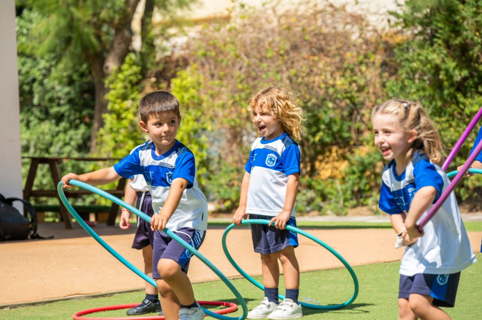 Early Years children playing with hoops in the school grounds at Colegio Internacional Torrequebrada